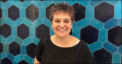 Sarah Maza behind funky blue backdrop