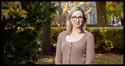 Kathleen Belew stands by Weber Arch during autumn